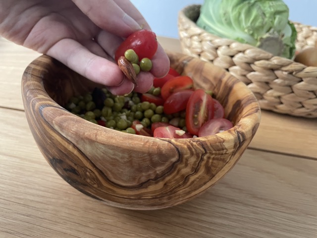 Eating peas and tomatoes with hands