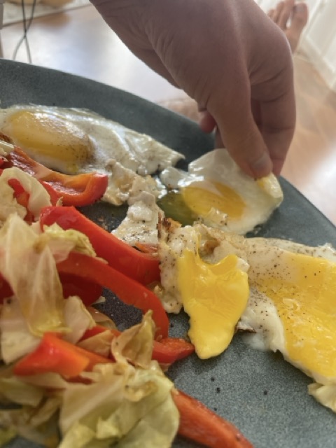 Eating a fried egg with hands