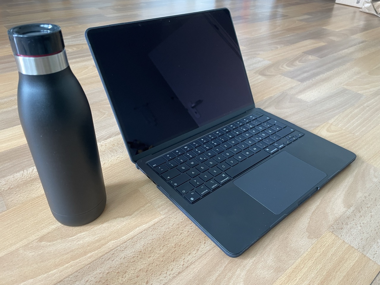 The minimalist black water bottle and laptop by Alexander Fufaev